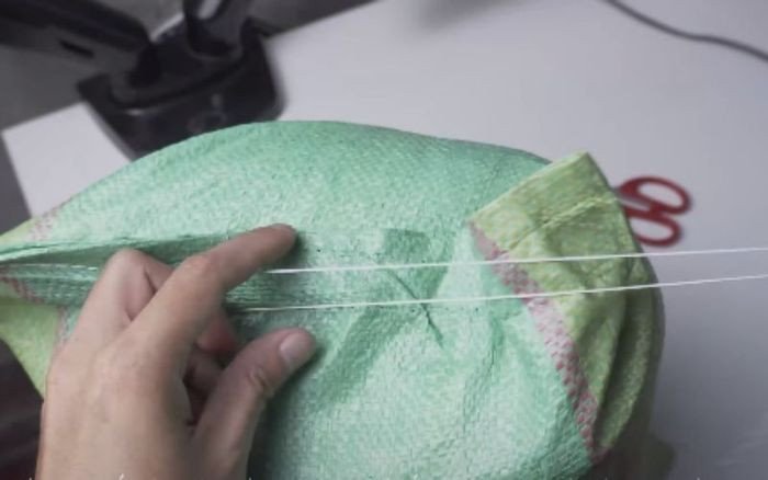 Hoàn tất mở bao gạo bằng cách kéo chỉ