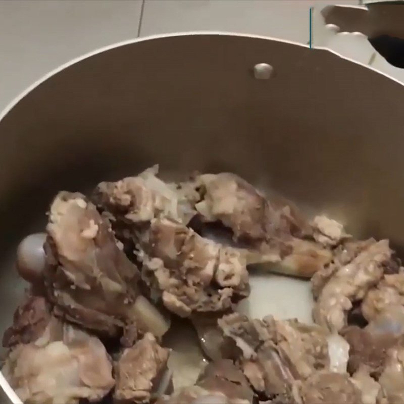 Nồi nước dùng xương heo đang sôi nhẹ, chuẩn bị cho món bánh canh